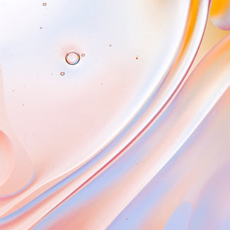 Abstract macro of peach and pale-blue serum swirls, evoking the fluid texture of a peptide treatment.