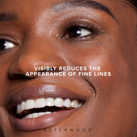 Close-up of a smiling woman with the headline 'visibly reduces the appearance of fine lines', illustrating eye serum results.