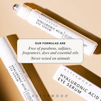 Two Hyaluronic Acid Eye Serum pens crossed on a tan surface with callout that formulas are free of parabens, sulfates, fragrances, dyes, essential oils, cruelty-free.