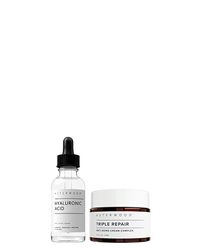 Asterwood Dew It Up Bundle: the clear Hyaluronic Acid serum dropper bottle beside the amber Triple Repair Cream jar with white lid.
