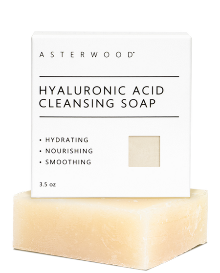 Asterwood Hyaluronic Acid Cleansing Soap 3.5 oz cream bar in front of its white carton labeled hydrating, nourishing, smoothing.