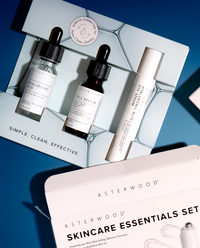 Skincare Essentials Set carton open against a deep blue surface, showing the three Asterwood serums in their cradle insert.