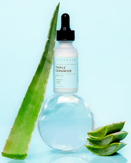 Asterwood Triple Ceramide Barrier Serum bottle with fresh aloe leaves and a clear gel orb on a soft aqua background.